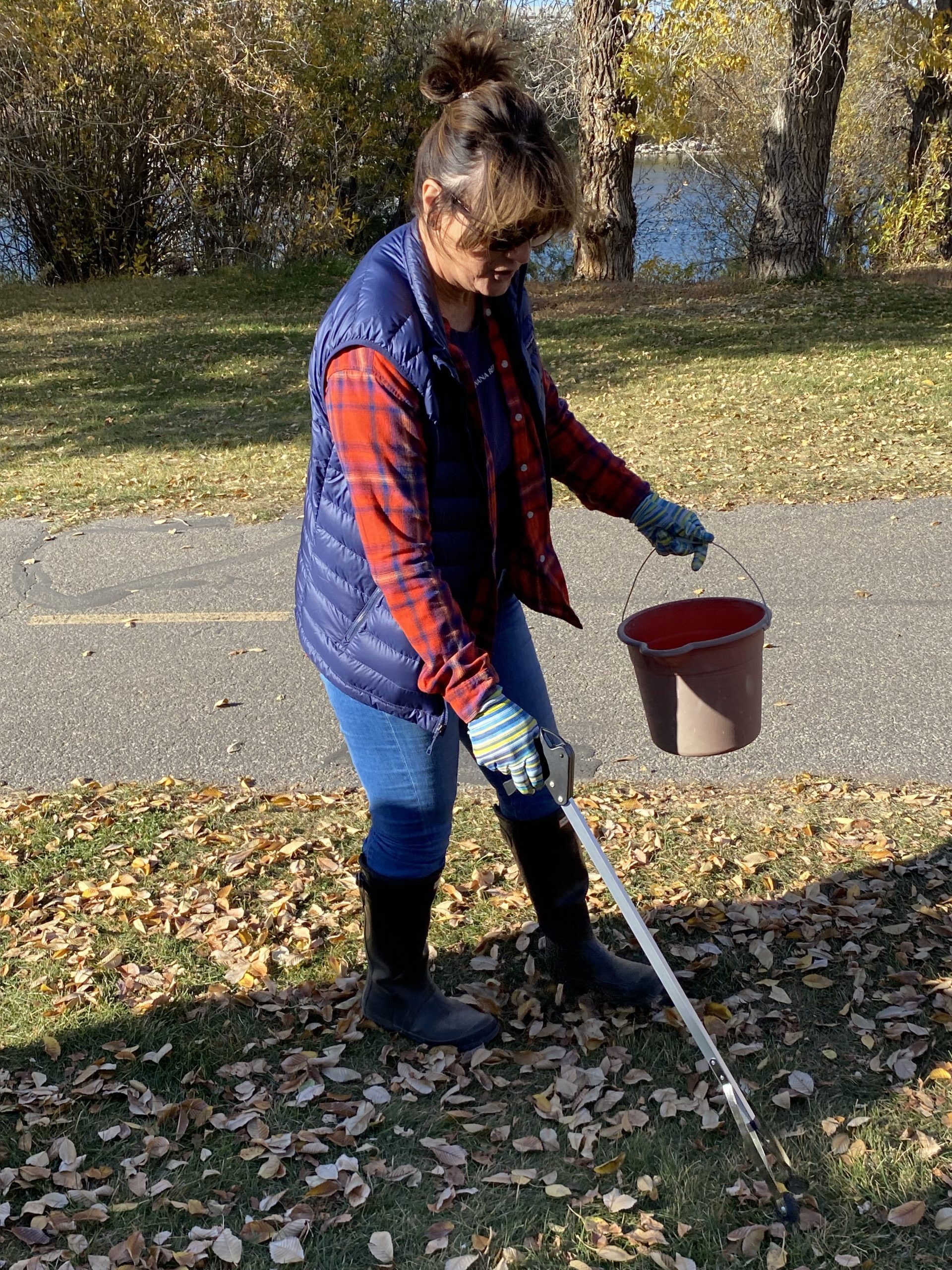 employee picks up trash along the River Walk 