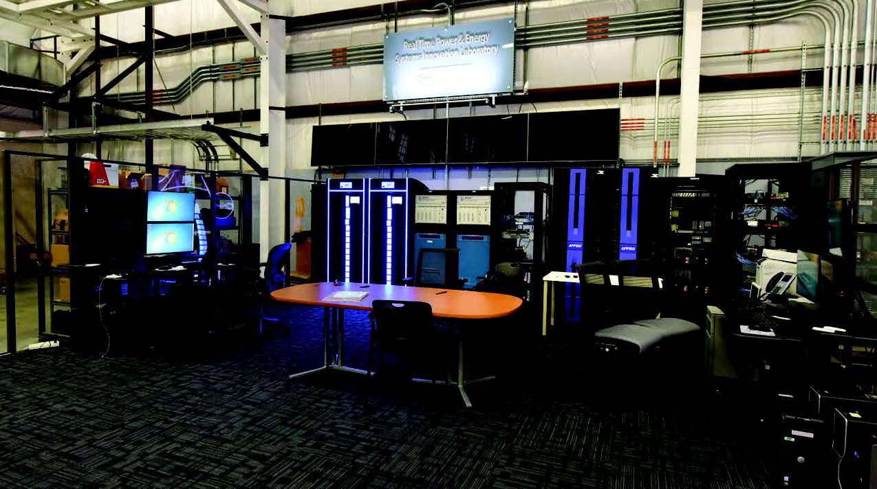 Power and energy systems laboratory with server racks, computer monitors, and a conference table.