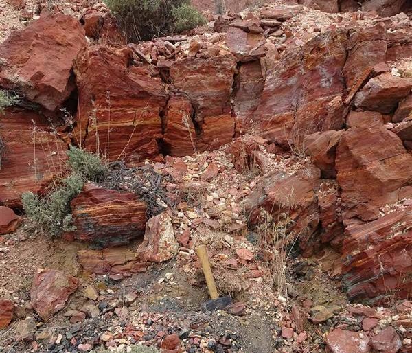 Obsidian deposit near Coal Banks Creek in southern Idaho. Clasts of black obsidian are visible on the lower left eroding from the slope below the red rhyolite.