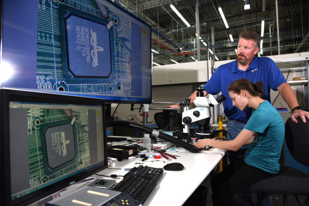 scientist looking at microchip through a microscope