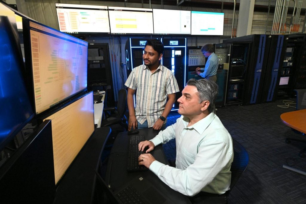 scientists looking at monitor data in the Power and Energy Real-Time Laboratory