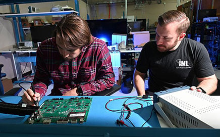 two men working on a computer board