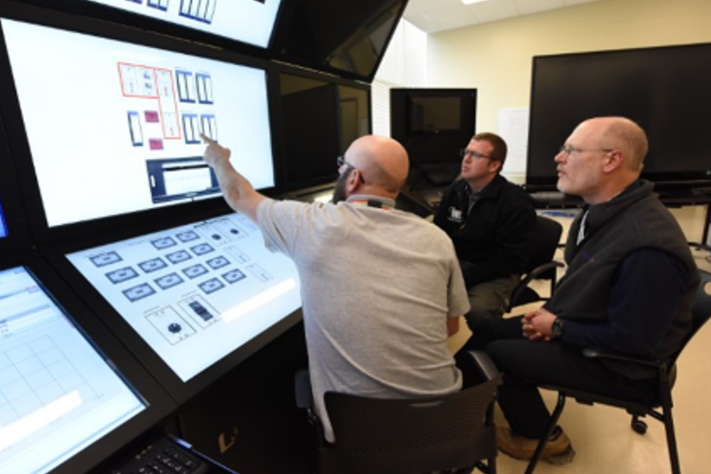 three men in modern TREAT control room