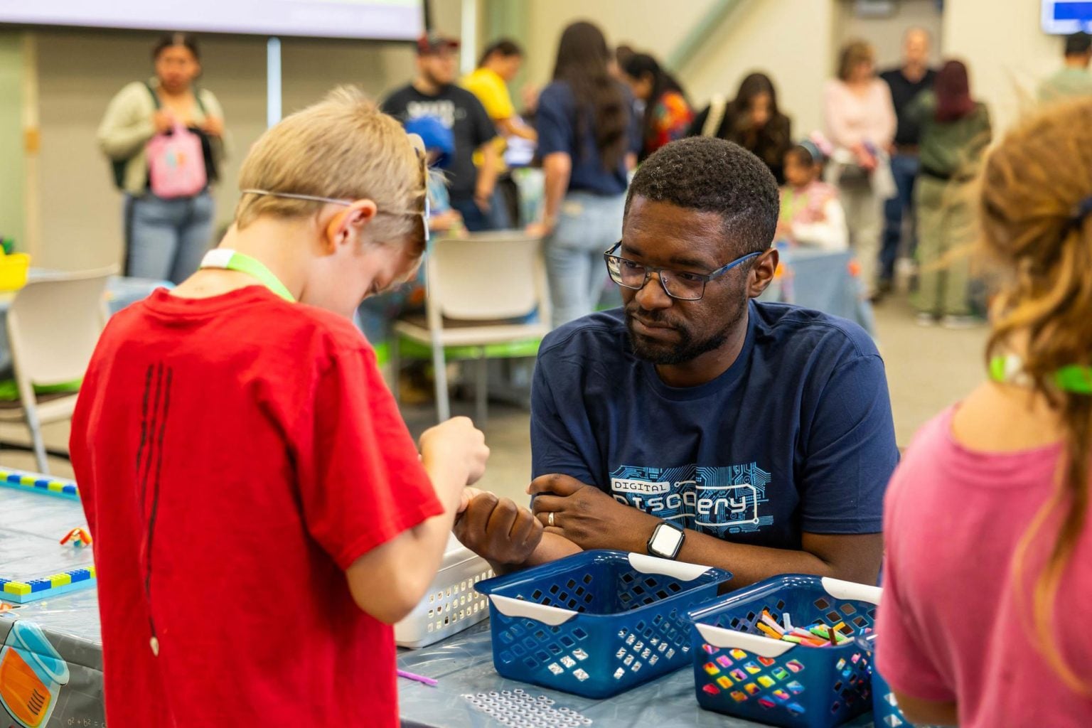 Adult mentoring a child during a hands-on STEM activity.