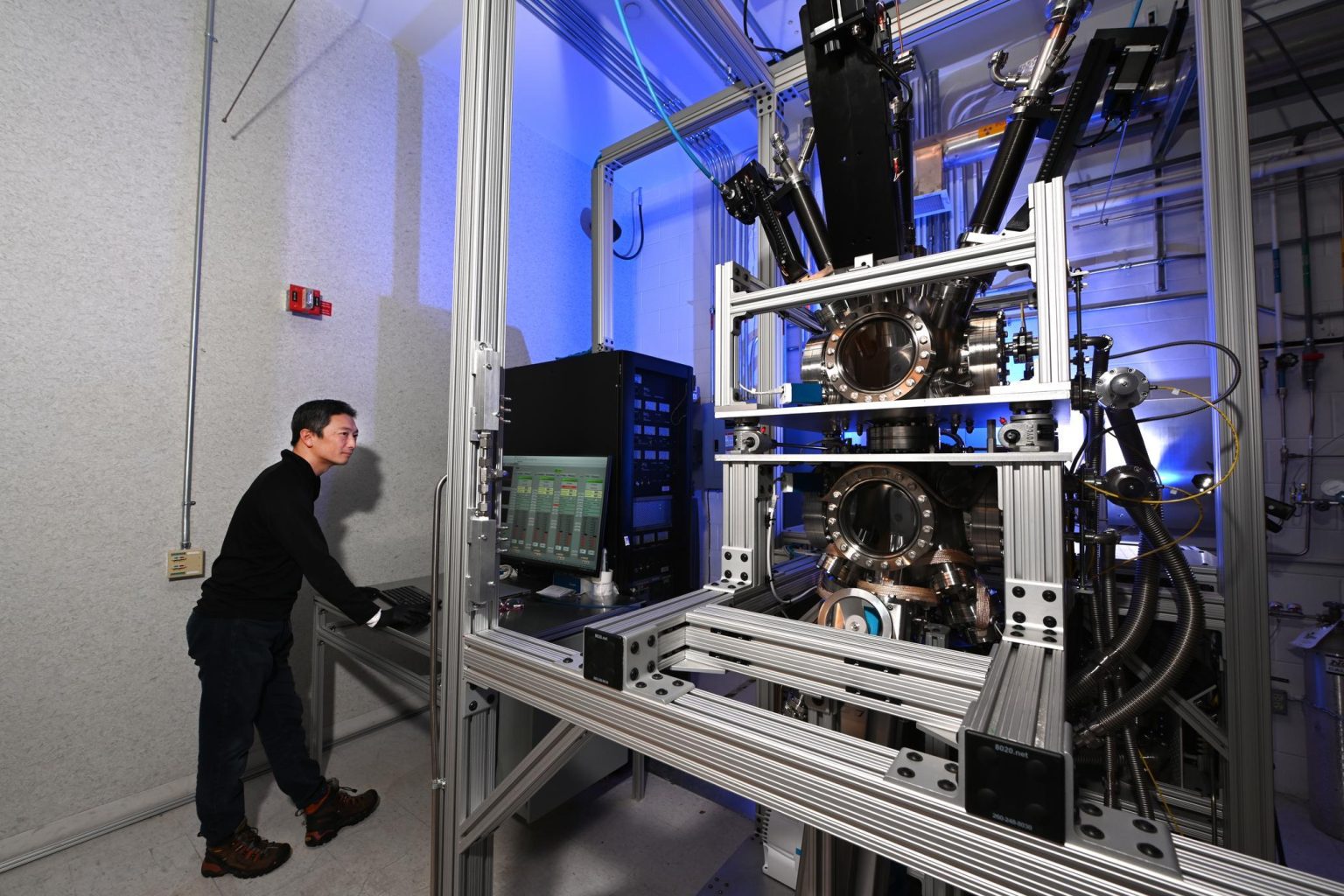 Researcher operating advanced laboratory equipment in a high-tech facility.
