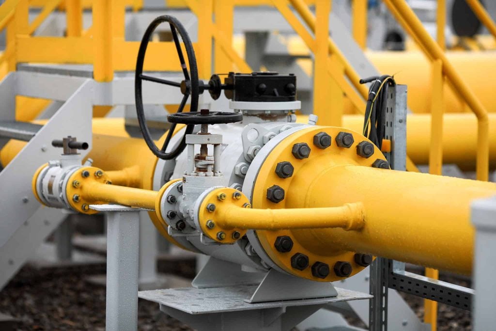 Industrial equipment (pipes, manometer/pressure gauge, levers, faucets, indicators) in a natural gas compressor station.