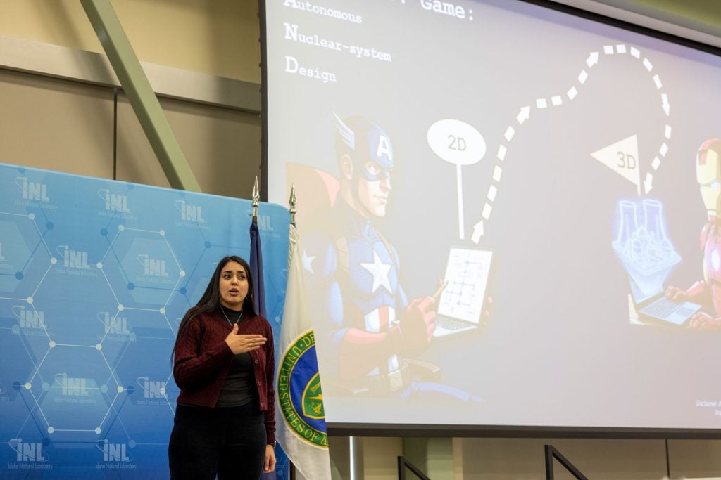 Women on stage presenting science on a slide show