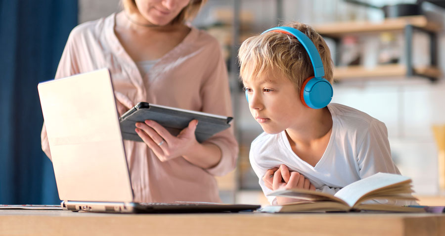 young student wearing headphones and watching an online educational video