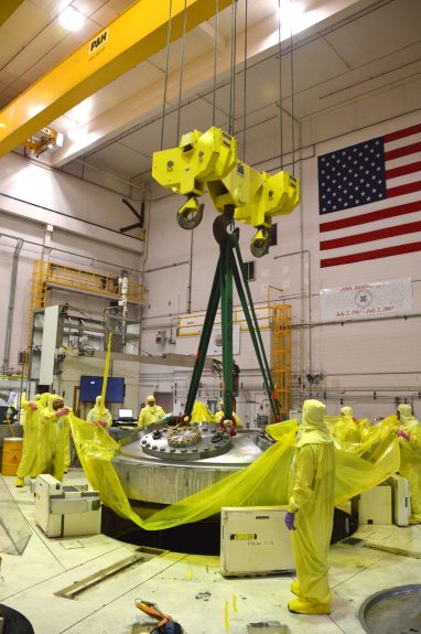 ATR employees remove the 31-ton top head from the reactor vessel, allowing access to the core components below.